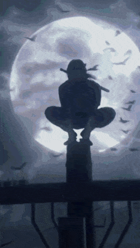 a silhouette of a person sitting on top of a pole in front of a full moon .