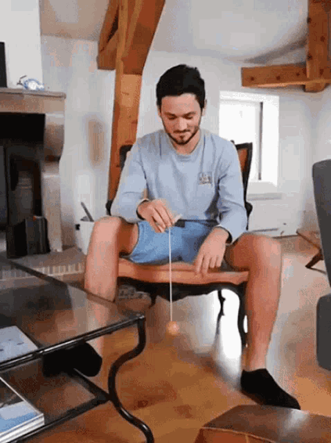 a man sitting on a chair playing with a toy