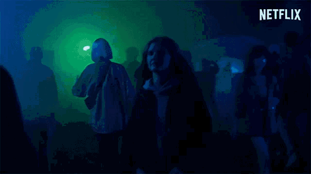 a woman is dancing in a dark room with a netflix logo behind her