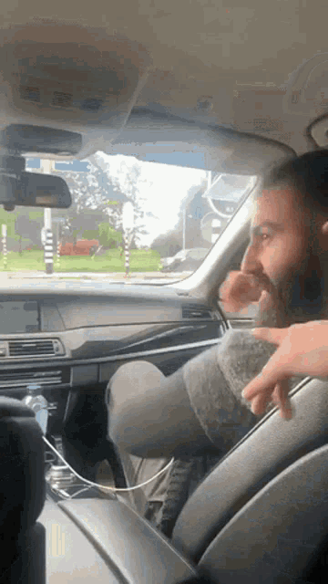 a man with a beard is sitting in a car