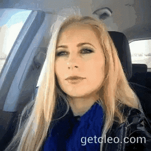 a woman is sitting in a car with the website getcleo.com in the lower right corner