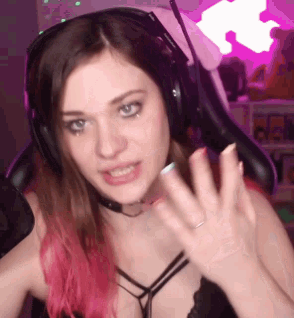 a woman with pink hair is wearing headphones and a microphone .