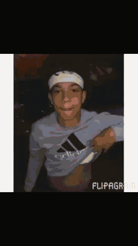 a young man wearing a headband and an adidas sweatshirt shows off his stomach