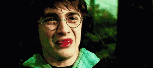 harry potter is crying with blood on his face and glasses .