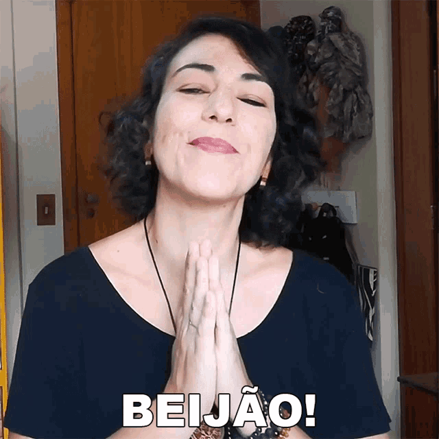 a woman with her hands folded and the word beijao written on her face