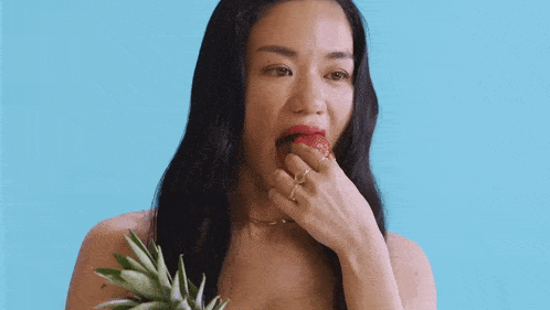 a woman is holding a pineapple and making a face