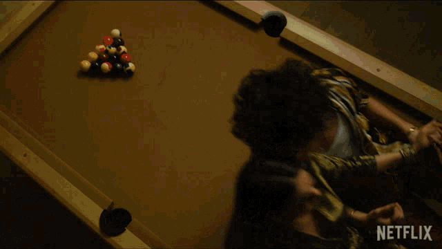 a man and a woman are laying on a pool table with netflix written on the bottom