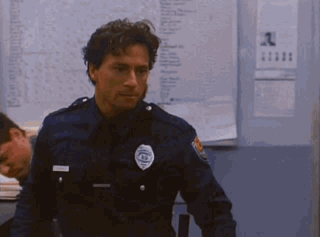 a police officer is kneeling down in a room with a yellow chair