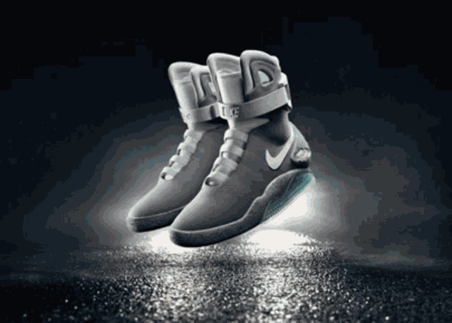 a pair of nike shoes floating in the air on a dark background