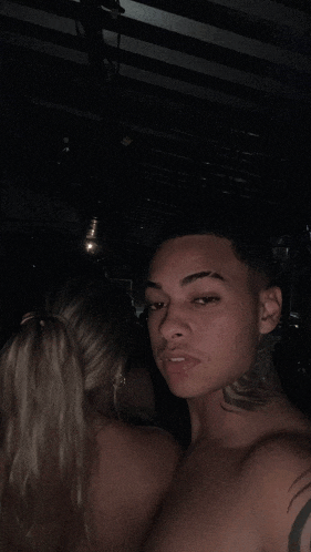 a man with a tattoo on his neck is standing next to a woman with a ponytail