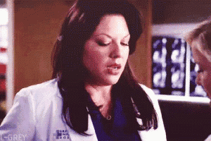 a woman in a white lab coat with the word grey on her chest
