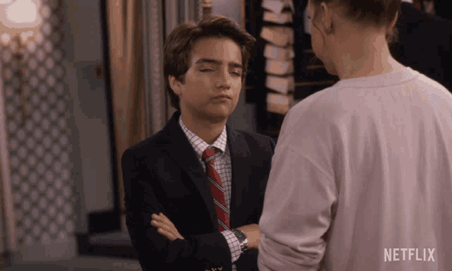 a man in a suit and tie is standing next to a woman in a netflix shirt