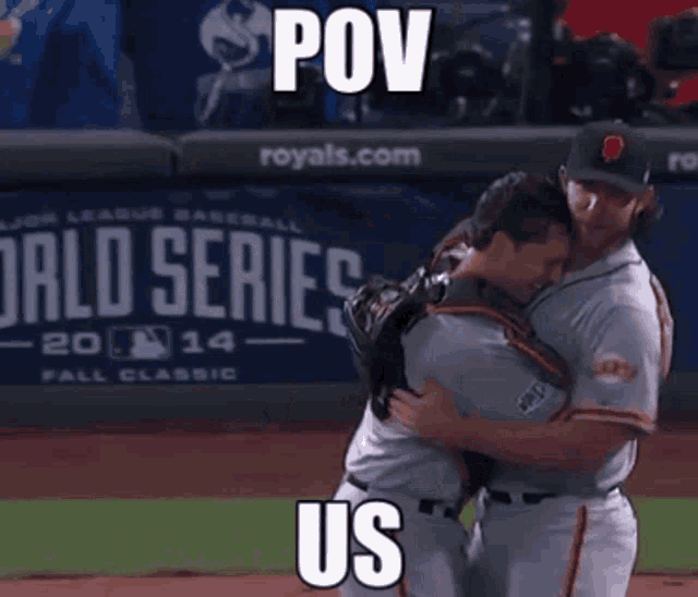 two baseball players are hugging each other on a field .