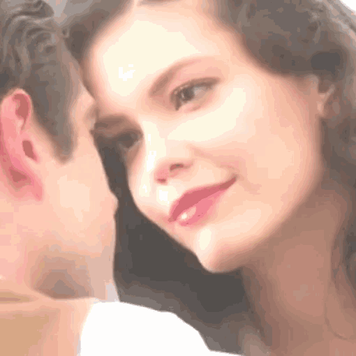 a close up of a woman 's face with a man kissing her on the cheek