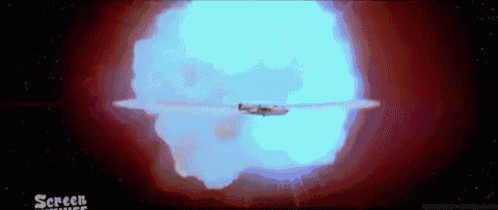a plane is flying through a blue and red explosion in the sky .