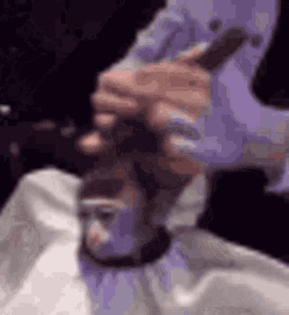 a man is getting his hair cut by a barber in a barber shop .
