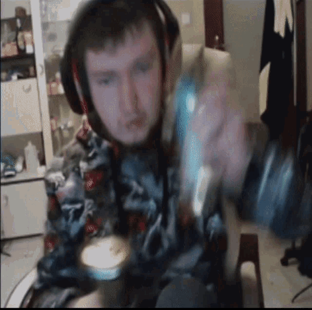 a man wearing headphones holds a can of soda