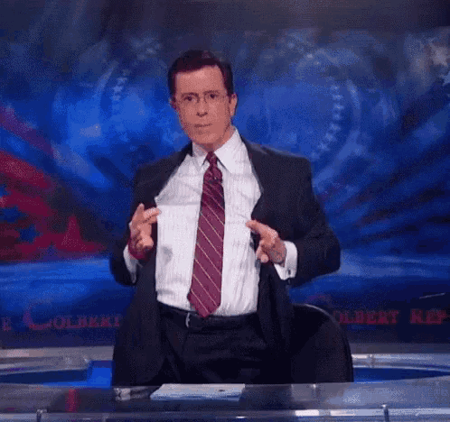 a man in a suit and tie is standing in front of a stage and says happy birthday .