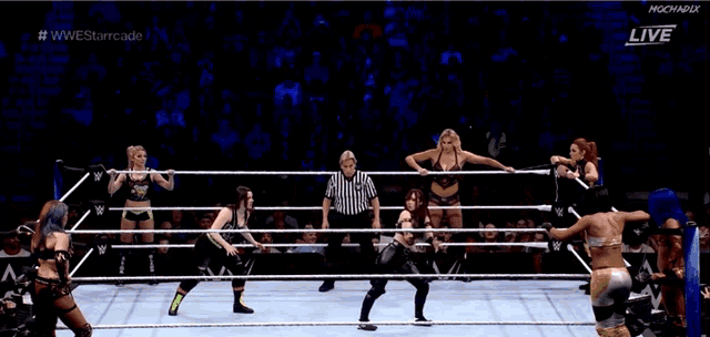 a couple of women are wrestling in a ring and one of them is holding a rope .