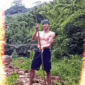 a man without a shirt is holding a pole in a forest