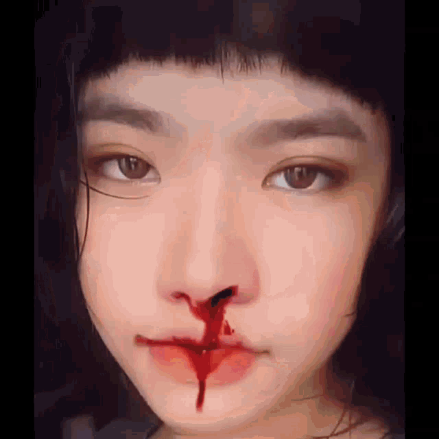 a girl with blood coming out of her nose .