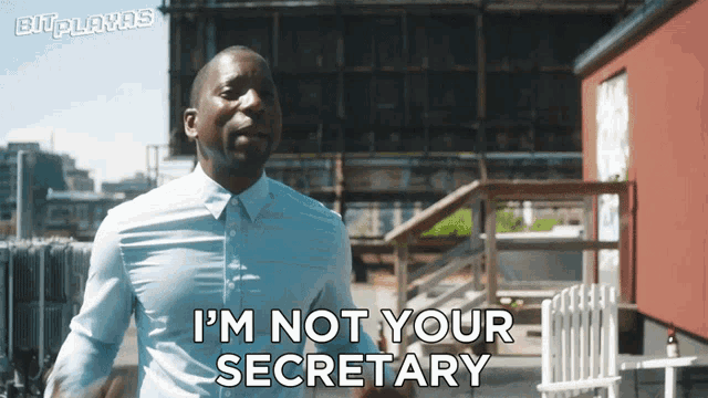a man says i 'm not your secretary in front of a red building
