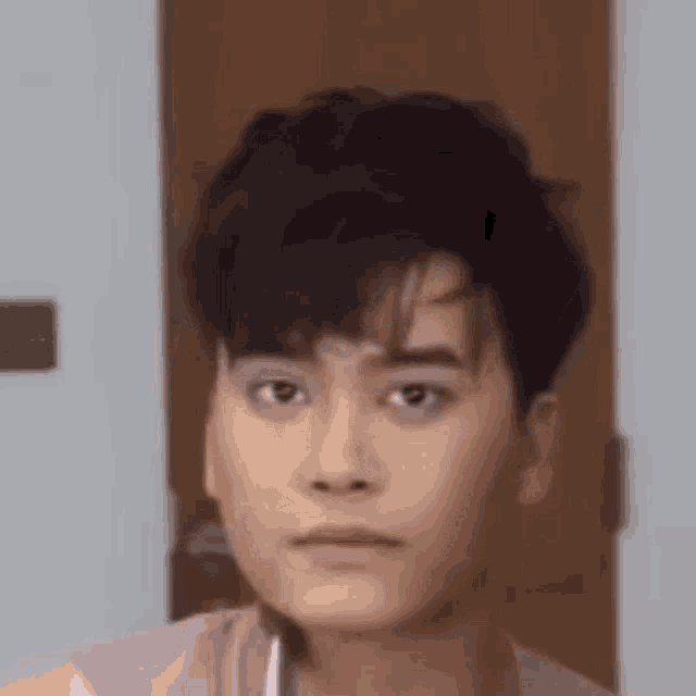 a close up of a young man applying makeup in a bathroom .