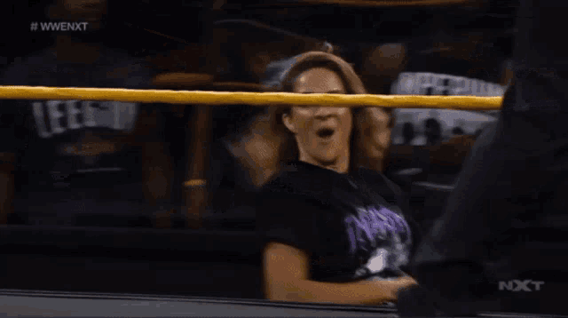 a woman in a wrestling ring is wearing a purple shirt that says industry