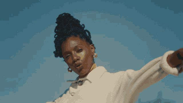 a woman with her arms outstretched wearing a white jacket