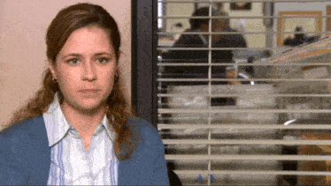 a woman sitting in front of a window with blinds that say a4