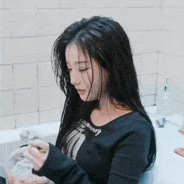 a woman in a bathtub wearing a black shirt that says anything