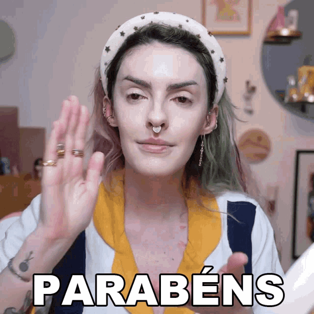 a woman with green hair is wearing a headband and says parabéns