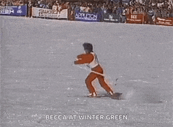 a person is skiing down a snow covered slope with their arms outstretched in front of a crowd .
