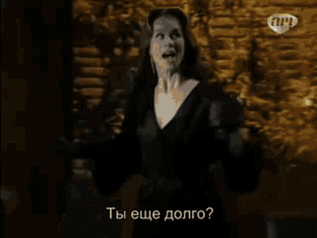 a woman in a black robe is standing in front of a lamp in a dark room .