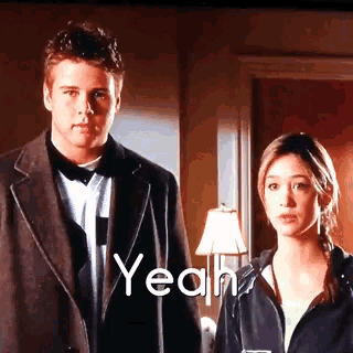 a man and a woman are standing next to each other and the word yeah is visible