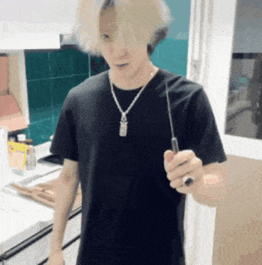 a man in a black t-shirt is holding a knife
