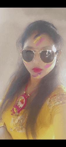 a woman with paint on her face wearing sunglasses and a yellow shirt