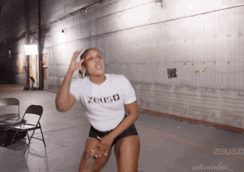 a woman in a white shirt that says zeus