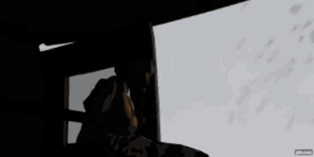 a person is sitting in a chair looking out a window .