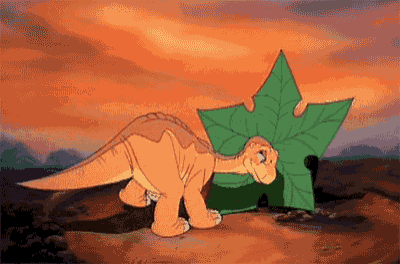 a cartoon of a dinosaur standing next to a green leaf