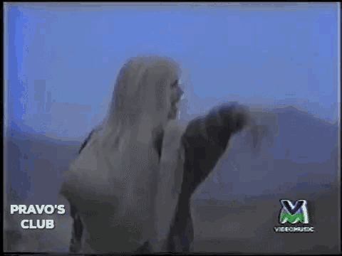 a woman with long white hair is standing in front of a blue sky in a video for pravo 's club .