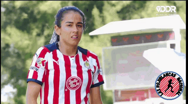 a female soccer player wearing a red and white striped shirt with a sticker that says ' sella hasta '