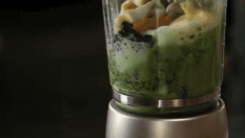 a blender is filled with a green smoothie