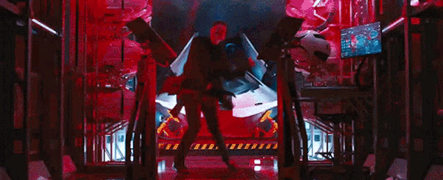 a man in a suit is standing in a room with a lot of machinery .