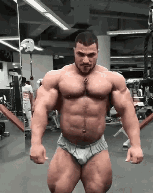 a man in underwear is standing in a gym .