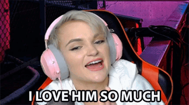 a woman wearing pink headphones is sitting in a chair and saying i love him so much