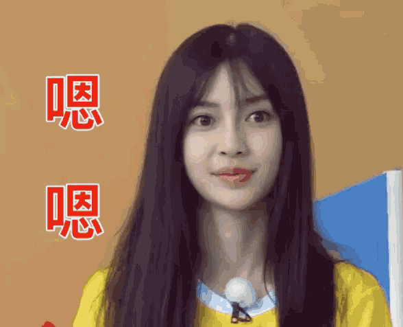 a woman with long black hair is wearing a yellow shirt and has chinese writing on her face