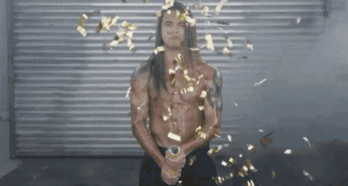 a shirtless man with long hair is standing in front of a garage door with confetti falling around him .