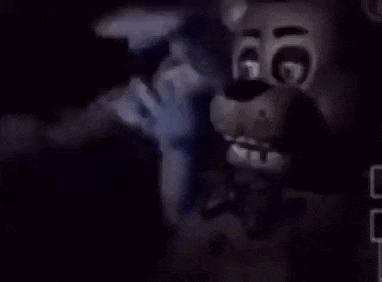 a teddy bear is holding a microphone in the dark .