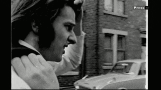 a black and white photo of a man talking on a cell phone with press written on the bottom right corner
